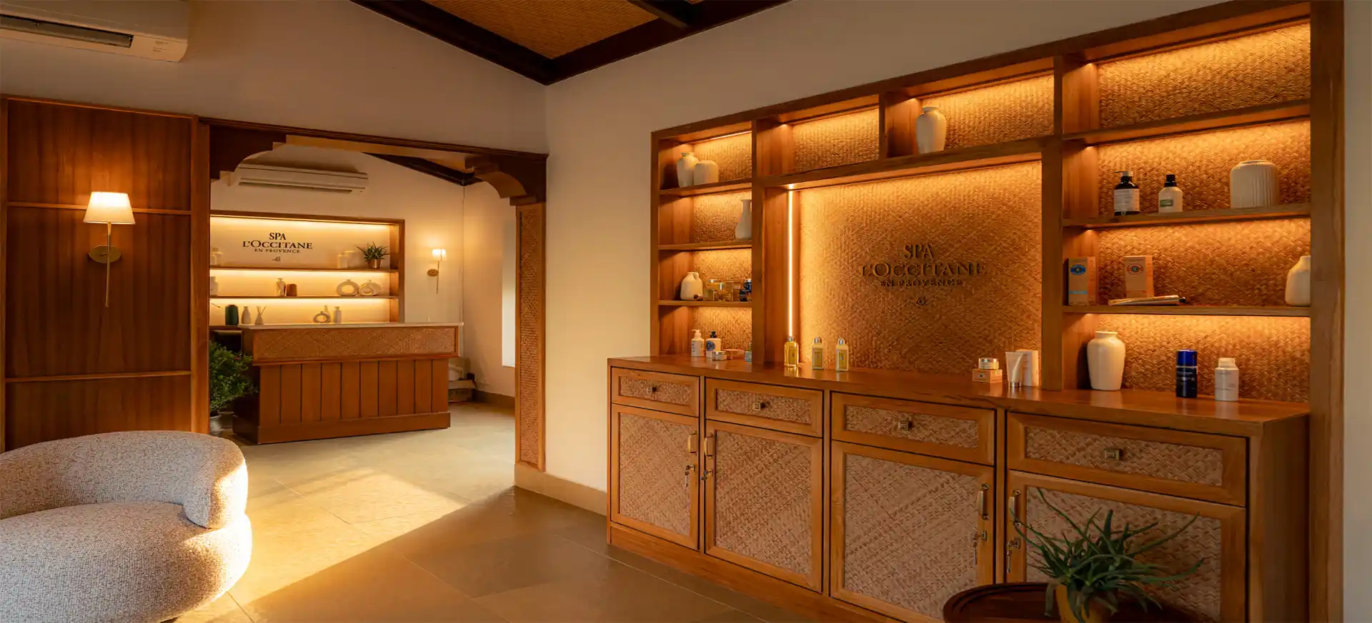 Spa L'OCCITANE treatment room in warm daylight, Provençal materials, full-width editorial photograph.