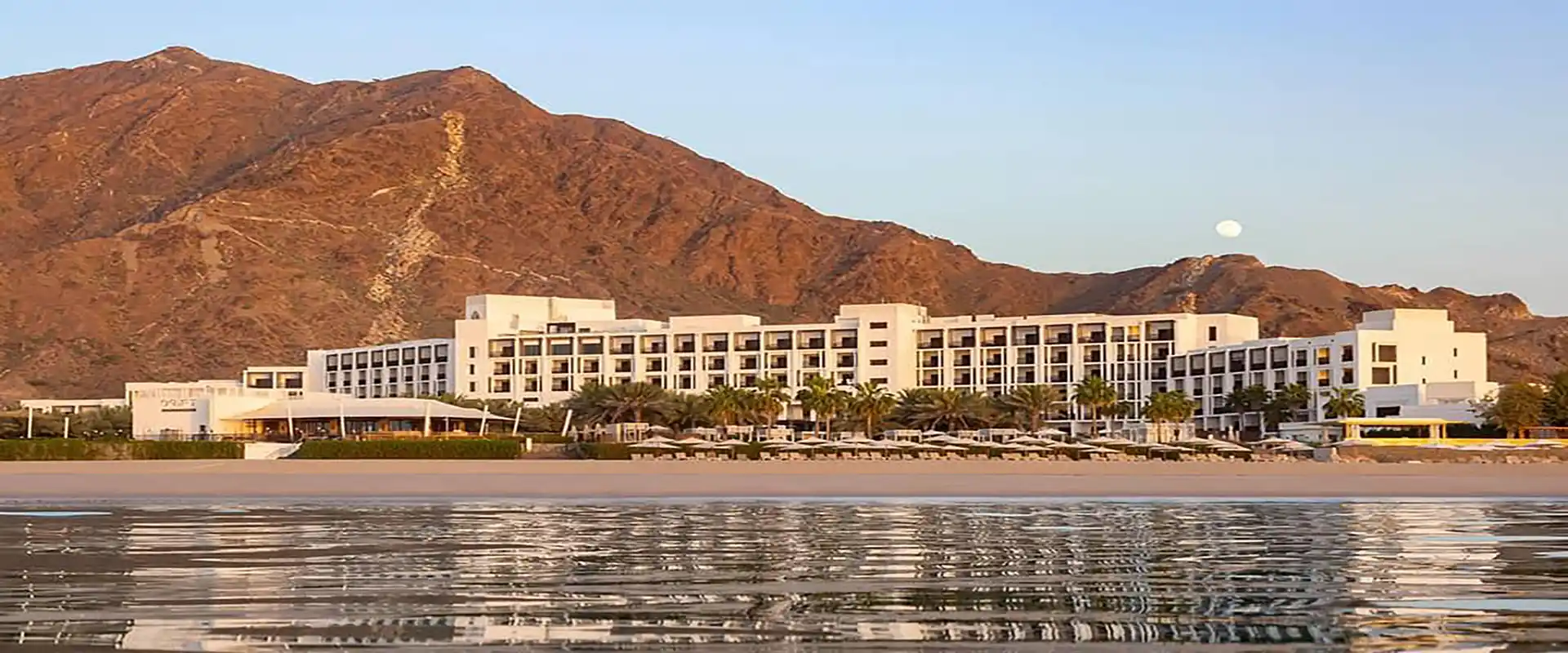 InterContinental Fujairah at dusk, exterior across the water.
