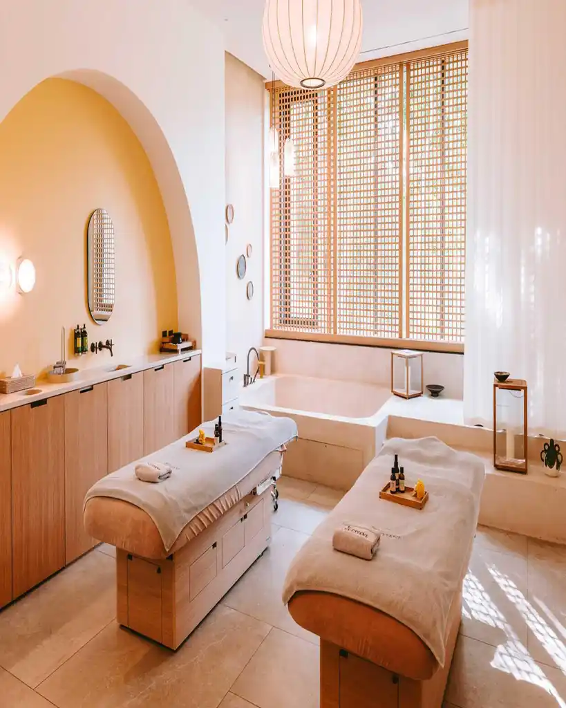 Spa L'OCCITANE treatment suite, warm daylight across Provençal stone and linen.